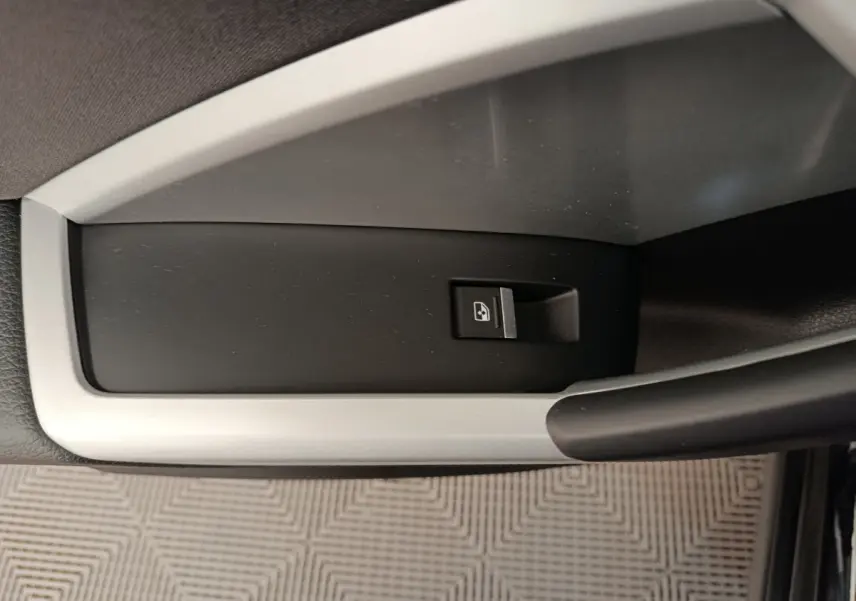Gros plan sur le bouton de verrouillage centralisé noir et argenté, situé sur la porte intérieure d’un Audi Q3 Sportback noir.