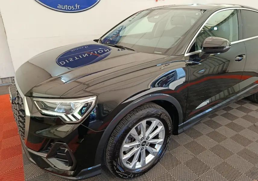 Audi Q3 Sportback noir en 3/4 avant droit, mettant en valeur ses phares LED et jantes alliage argentées.