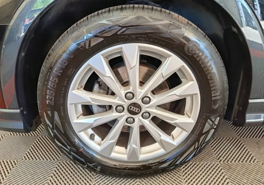Gros plan sur la roue avant droite de l’Audi Q3 Sportback noir, avec jante alliage argentée et pneu Continental.