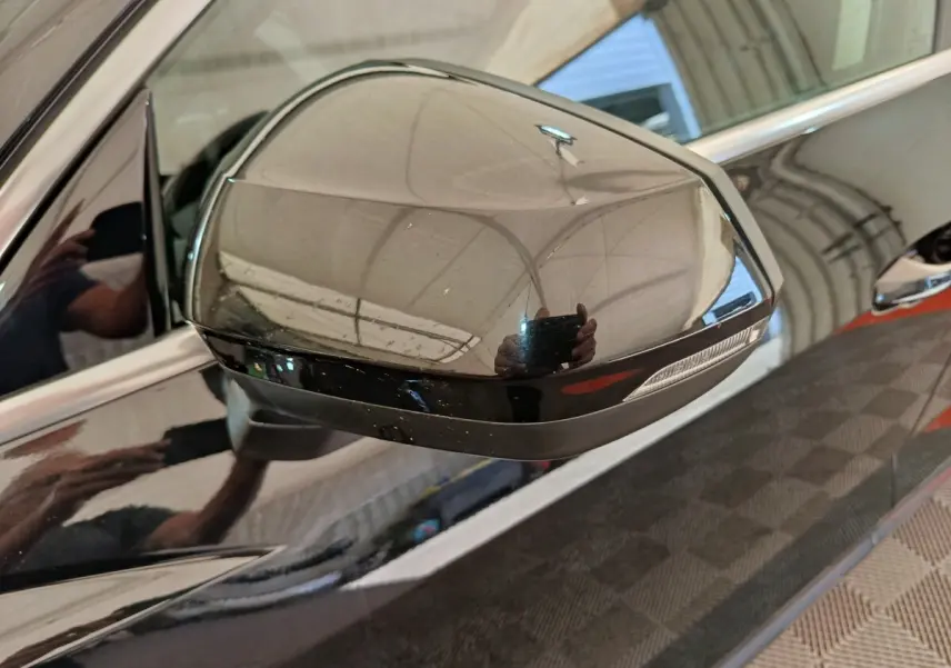 Gros plan sur le rétroviseur droit noir brillant de l'Audi Q3 Sportback 35 TDI 150 Business Line 2023.