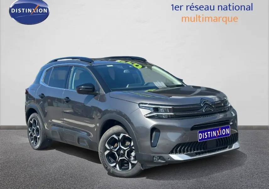 Citroën C5 Aircross gris Platinium vue 3/4 avant droit avec jantes alu et barres de toit visibles.