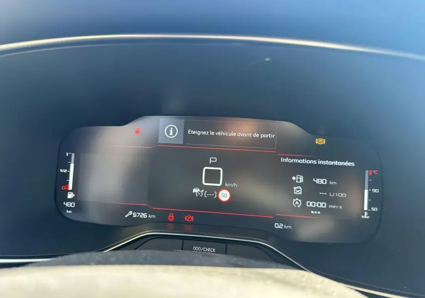 Tableau de bord numérique de Citroën C5 Aircross 2025 affichant la vitesse, alertes et autonomie, vue frontale rapprochée.
