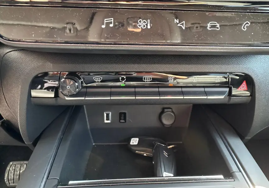 Vue rapprochée de la console centrale du Citroën C5 Aircross 2025 avec commandes climatisation et clé dans le rangement.