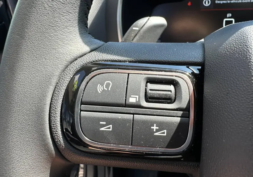 Gros plan sur les commandes multifonctions noires à gauche du volant du Citroën C5 Aircross 2025.