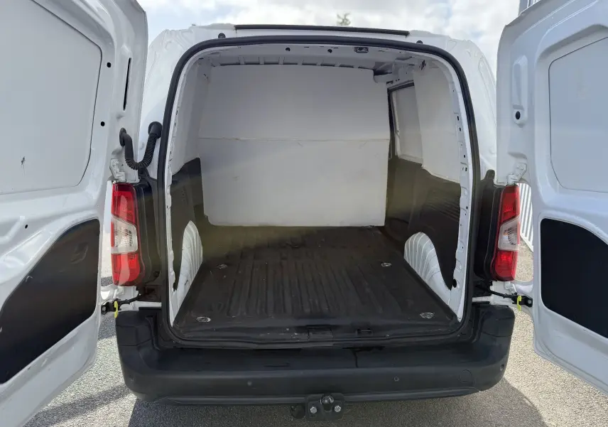 Vue arrière ouverte du Peugeot Partner blanc 2021 montrant l'espace de chargement vide et le crochet d'attelage noir.