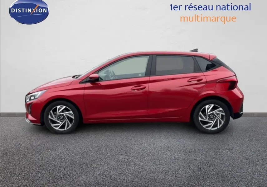 Profil côté gauche d'une Hyundai i20 2025 rouge Dragon Metal avec jantes alliage et lignes dynamiques marquées.