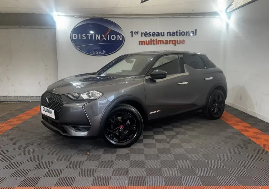 DS3 Crossback BlueHDi 110 gris foncé en 3/4 avant droit avec jantes noires et toit noir dans un showroom.