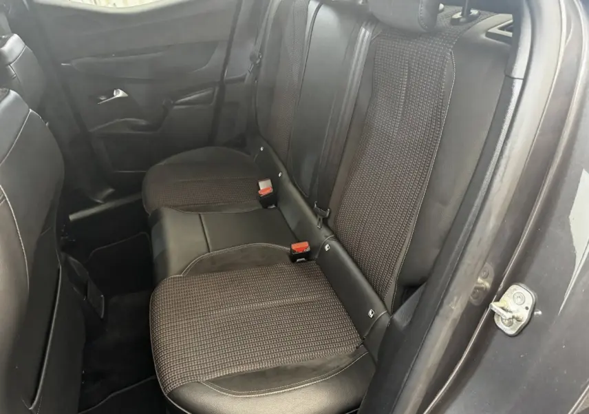 Vue côté droit de la banquette arrière en tissu et cuir noir du DS3 Crossback gris foncé, avec ceinture de sécurité visible.