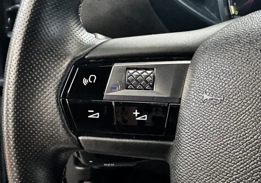 Gros plan sur le volant cuir noir perforé du DS3 Crossback 2021 avec commandes multifonctions intégrées.