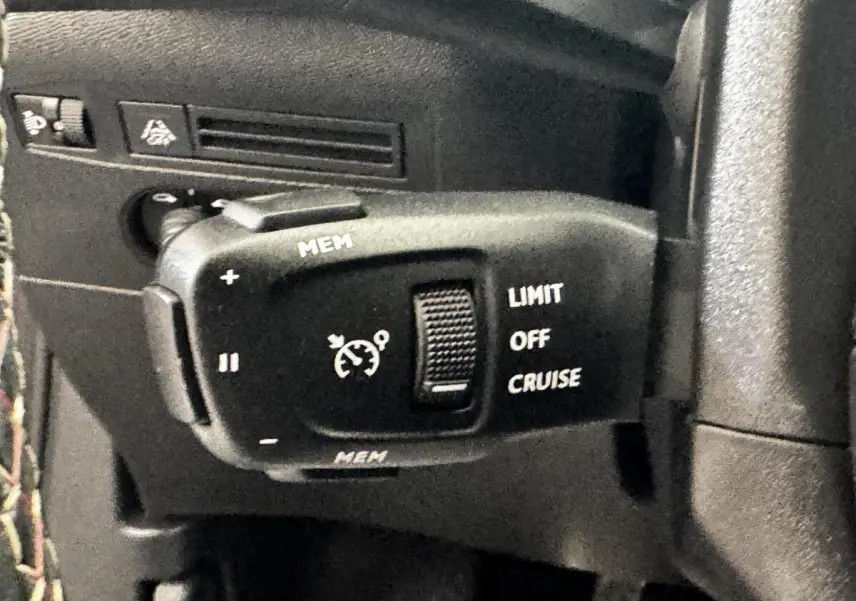 Gros plan sur la commande de régulateur de vitesse et limiteur, intérieur noir du DS3 Crossback gris foncé.