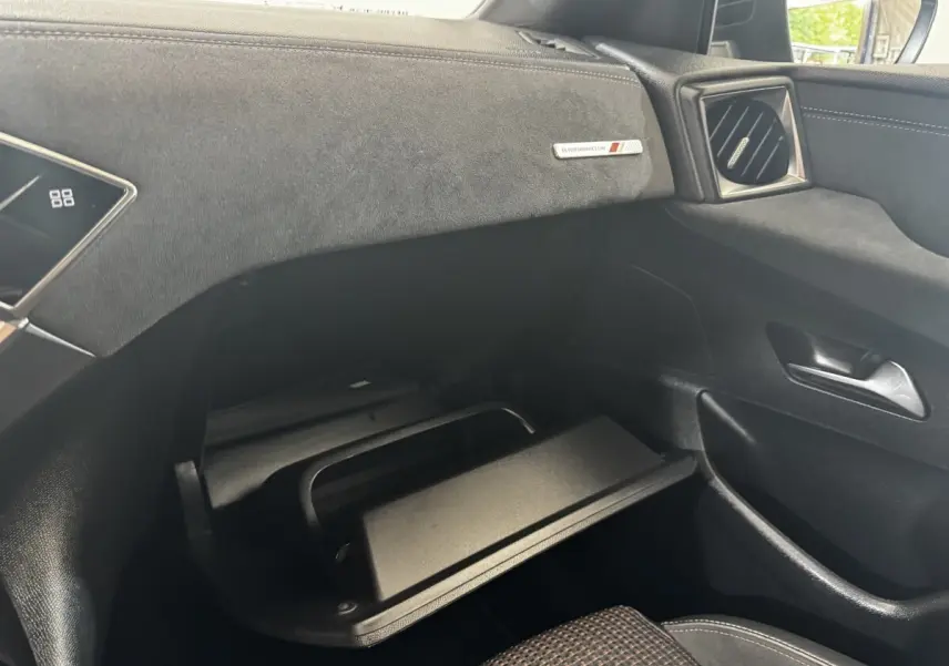 Vue intérieure côté passager du tableau de bord gris foncé avec boîte à gants ouverte du DS3 Crossback BlueHDi 110 Performance Line.