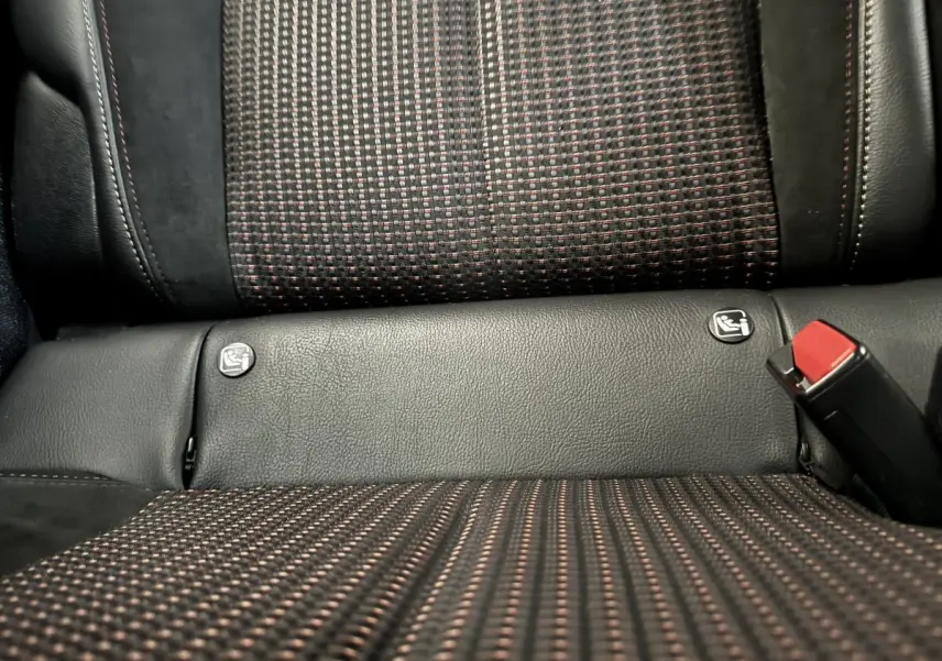 Gros plan sur la banquette arrière grise et noire du DS3 Crossback avec logos Isofix et ceinture de sécurité rouge visible.