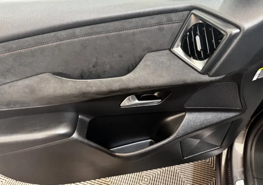 Vue intérieure du panneau de porte côté conducteur du DS3 Crossback gris foncé, avec garniture en alcantara et insert noir.