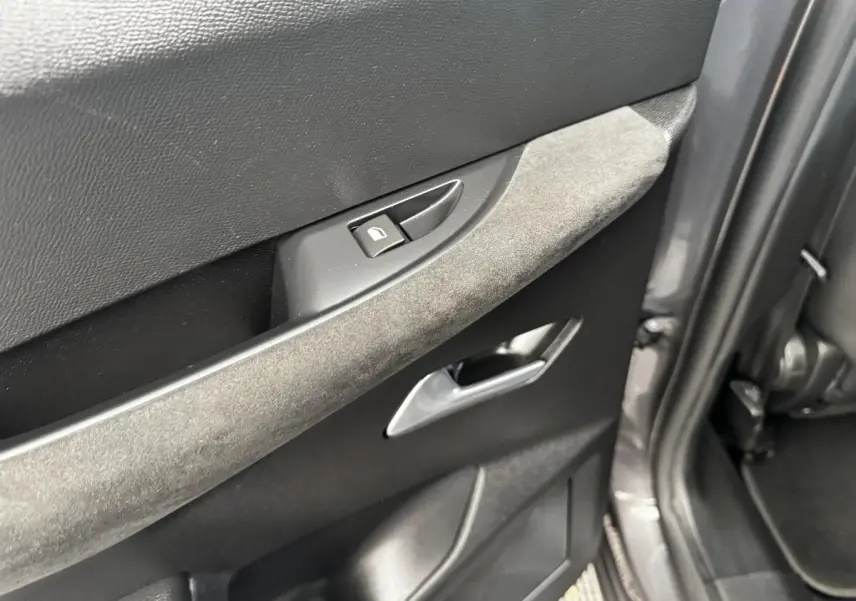 Détail de la porte arrière droite grise du DS3 Crossback 2021 avec poignée intérieure argentée et bouton de verrouillage.