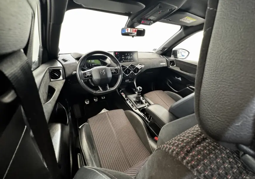 Vue intérieure avant du DS3 Crossback 2021 gris foncé, volant cuir multifonctions et écran tactile central.
