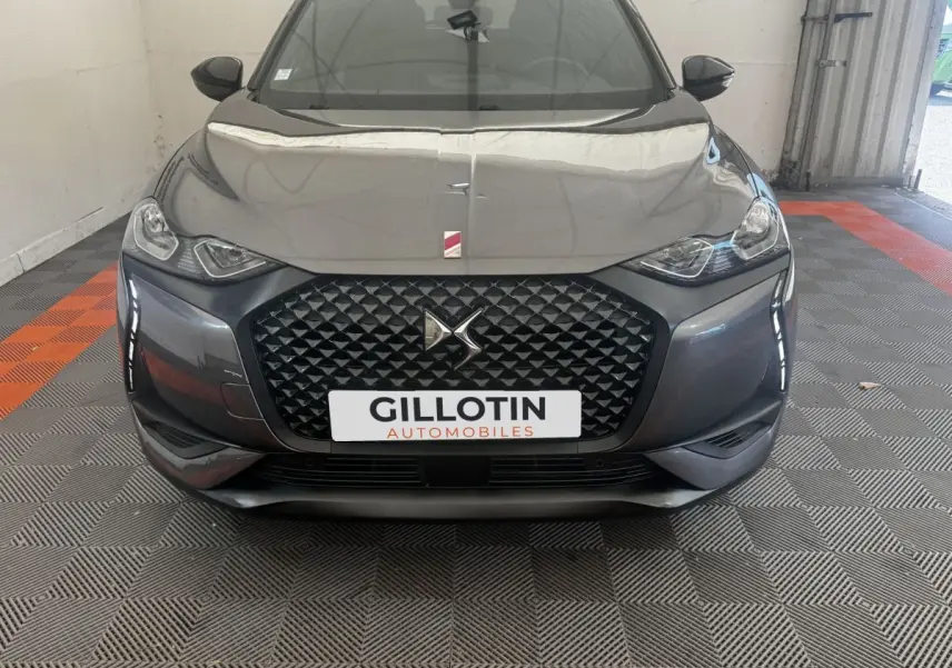 Vue avant d'une DS3 Crossback gris foncé avec calandre noire texturée et phares LED distinctifs.