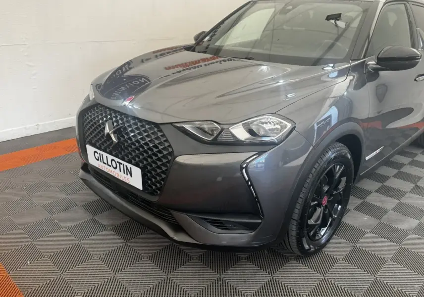 DS3 Crossback gris foncé vu en 3/4 avant droit, avec calandre noire et jantes noires brillantes.