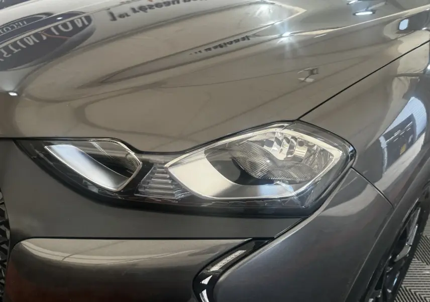 Gros plan sur le phare avant droit gris foncé du DS3 Crossback avec détails du capot et pare-chocs.