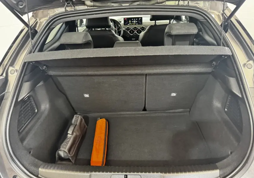 Coffre ouvert d’un DS3 Crossback gris foncé, vue arrière montrant l’espace de chargement et l’intérieur avec sièges noirs.