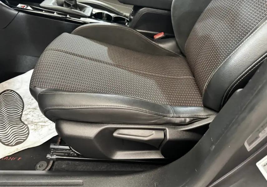 Gros plan sur le siège avant droit en tissu et cuir du DS3 Crossback gris foncé, avec levier de réglage manuel visible.