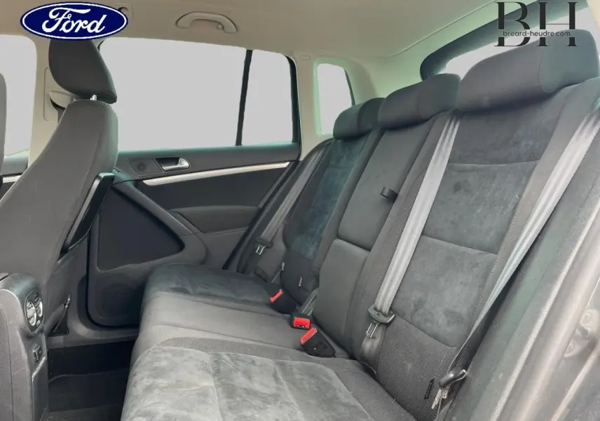 Vue intérieure côté droit de la banquette arrière grise du Volkswagen Tiguan 2014 avec ceintures et appuie-têtes visibles.