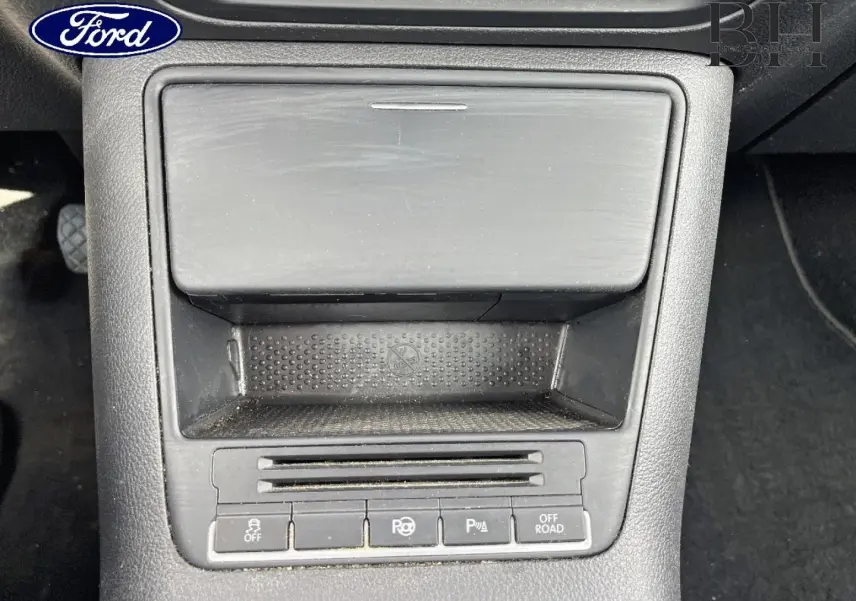 Gros plan sur la console centrale noire du Volkswagen Tiguan 2014, montrant les boutons d'aide au stationnement et mode off-road.