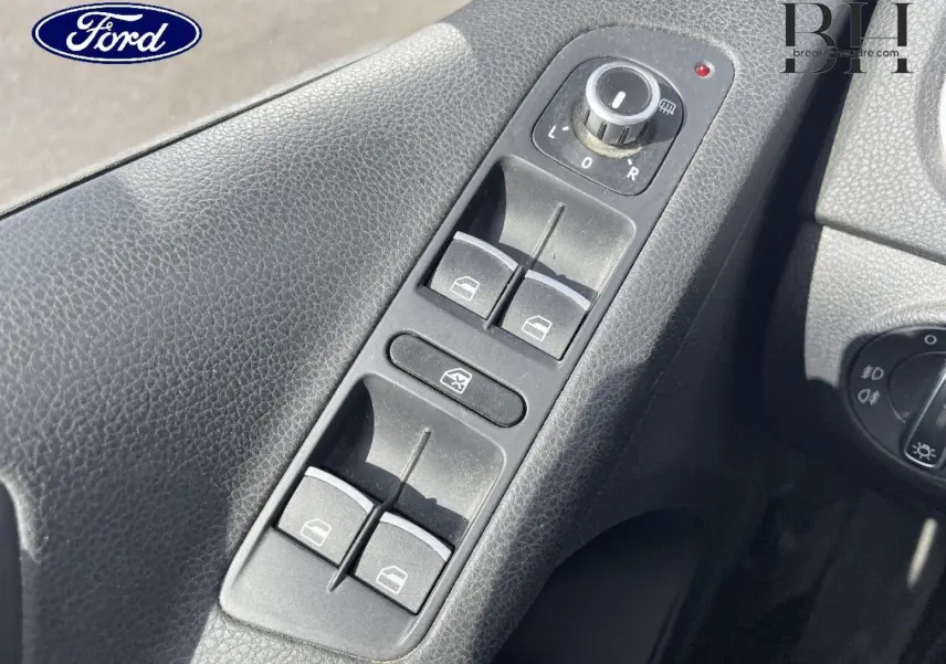 Panneau de commandes des vitres électriques et réglage des rétroviseurs côté conducteur d’un véhicule, avec logo Ford visible.