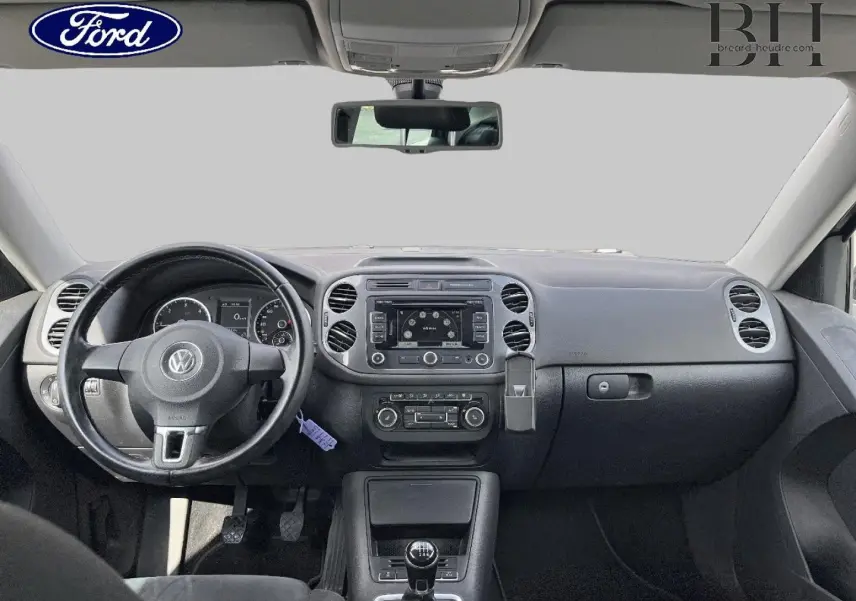 Vue intérieure frontale du tableau de bord noir et volant cuir du Volkswagen Tiguan 2014 avec boîte manuelle.