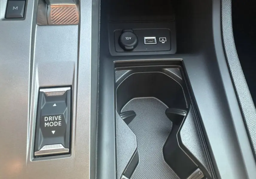 Gros plan sur la console centrale de la Peugeot 308 SW blanche, avec bouton Drive Mode et prises 12V et USB visibles.