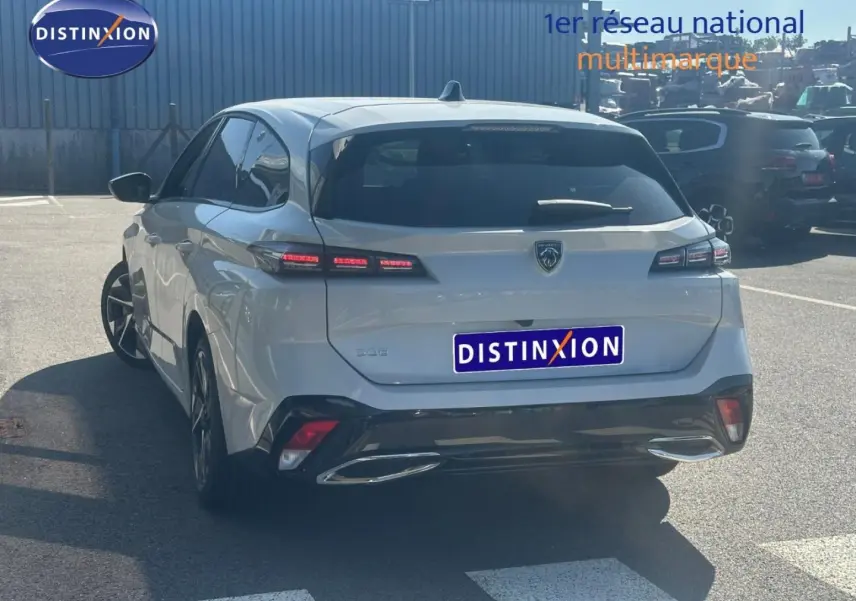 Vue 3/4 arrière d'une Peugeot 308 SW blanche Okénite avec feux arrière LED et lunette arrière surteintée.
