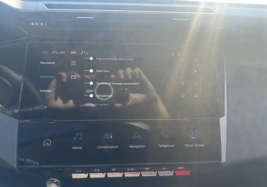 Écran tactile central avec menu des aides à la conduite dans l’habitacle d’une Peugeot 308 SW blanc Okénite.