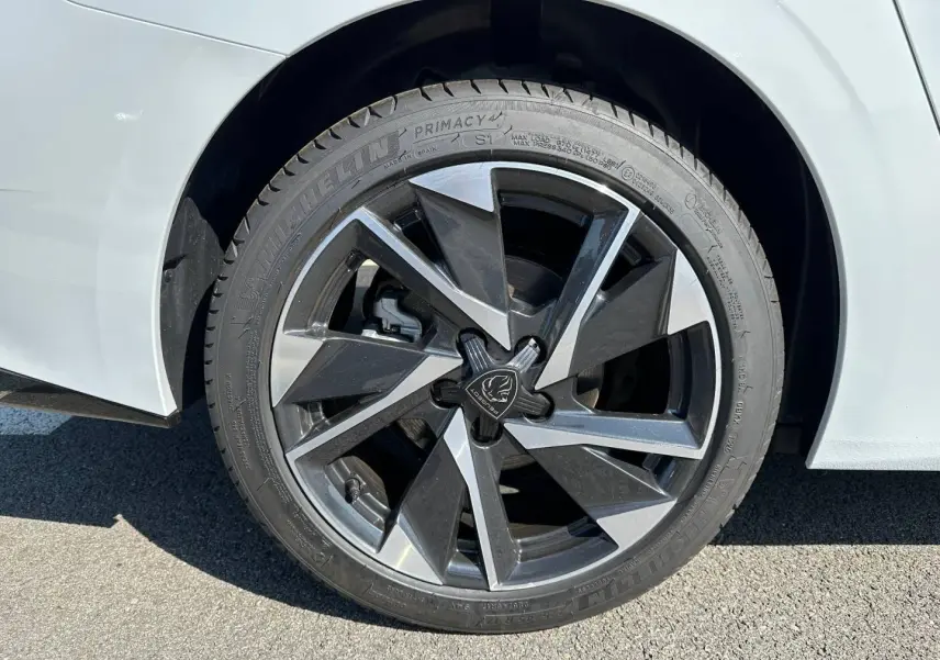 Gros plan sur la jante alu noire et argentée d'une Peugeot 308 SW blanche côté arrière droit.
