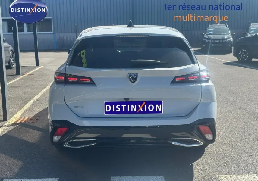 Vue arrière d'une Peugeot 308 SW blanche Okénite avec feux LED et double sortie d'échappement chromée.