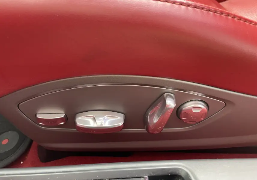 Gros plan sur les commandes électriques des sièges en cuir rouge grenat d'une Porsche Boxster S 2012