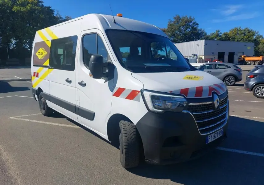 Renault Master cabine approfondie blanc en 3/4 avant droit avec bandes rouges et gyrophare orange sur le toit.