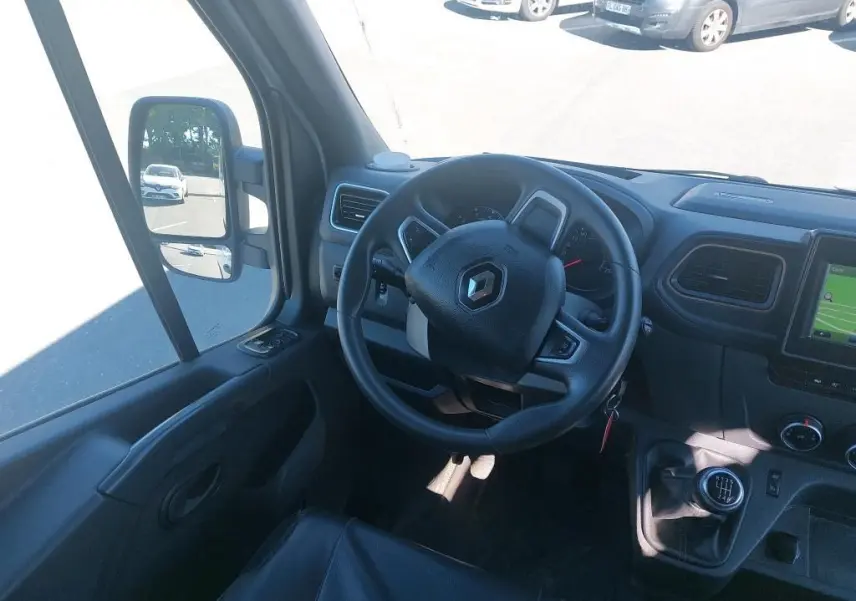 Intérieur du Renault Master L2H2 blanc 2021, vue du poste de conduite avec volant, tableau de bord et levier de vitesses manuel.
