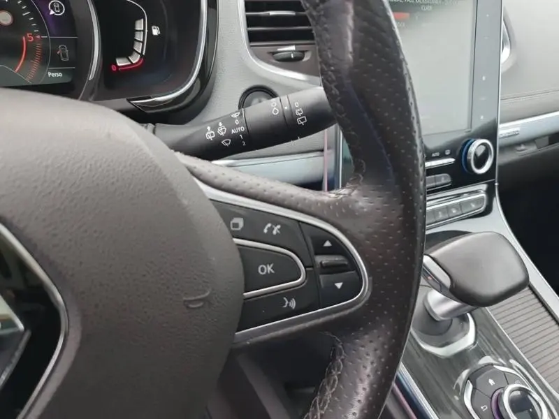 Vue rapprochée du volant en cuir et de la console centrale du Renault Espace blanc nacré 2017, avec écran tactile vertical.