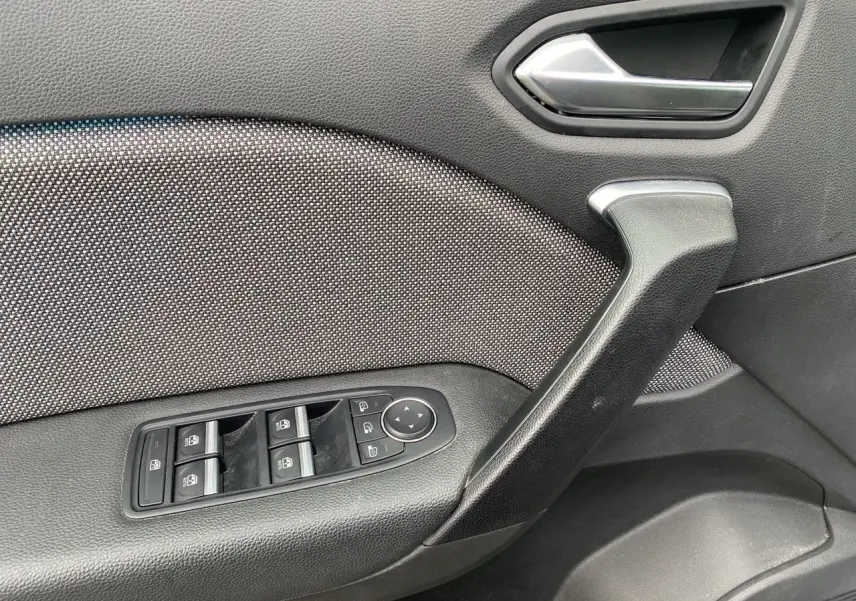 Détail de la porte côté conducteur du Renault Captur gris Cassiopée, avec commandes des vitres et rétroviseurs électriques.