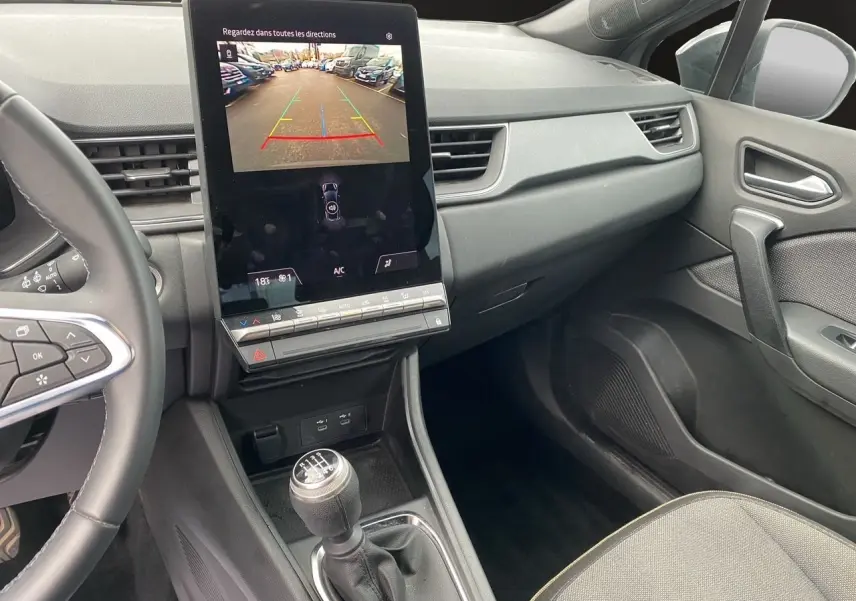 Vue intérieure côté passager du tableau de bord noir et écran tactile affichant la caméra de recul du Renault Captur 2025.