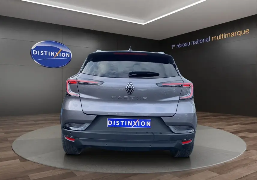 Vue arrière d'un Renault Captur gris Cassiopée avec toit noir, barres de toit et vitres arrière surteintées.