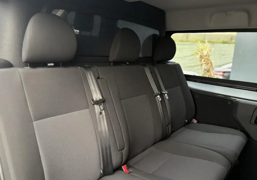 Vue intérieure de la banquette arrière 3 places en tissu bi-ton gris du Citroën Jumpy XL 2025, avec appuie-têtes et ceintures visibles.