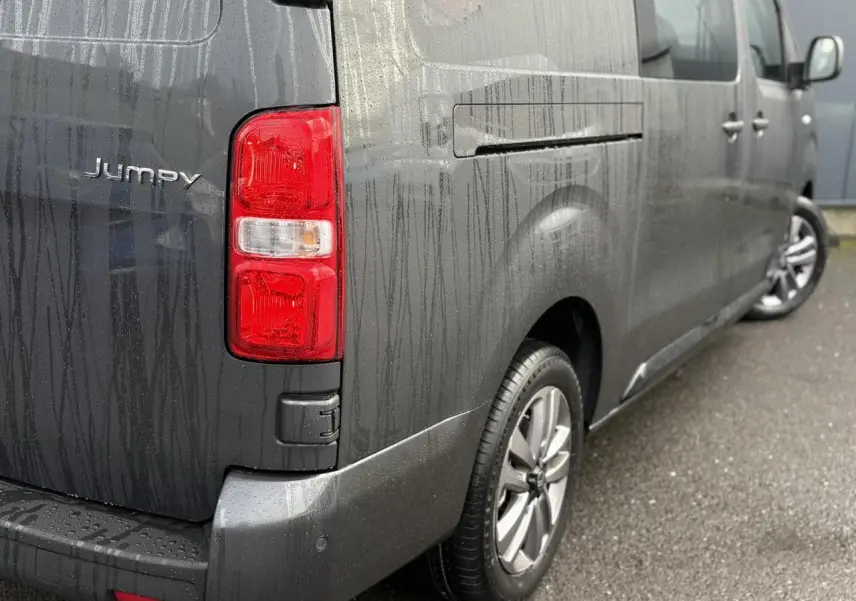 Vue 3/4 arrière droite d'un Citroën Jumpy XL gris titane avec jantes alliage 17'' et feux arrière rouges.