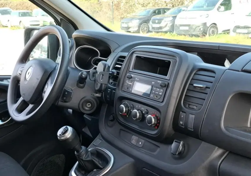 Vue intérieure côté conducteur du Renault Trafic Fourgon 2021, montrant le volant, la boîte manuelle et la console centrale noire.