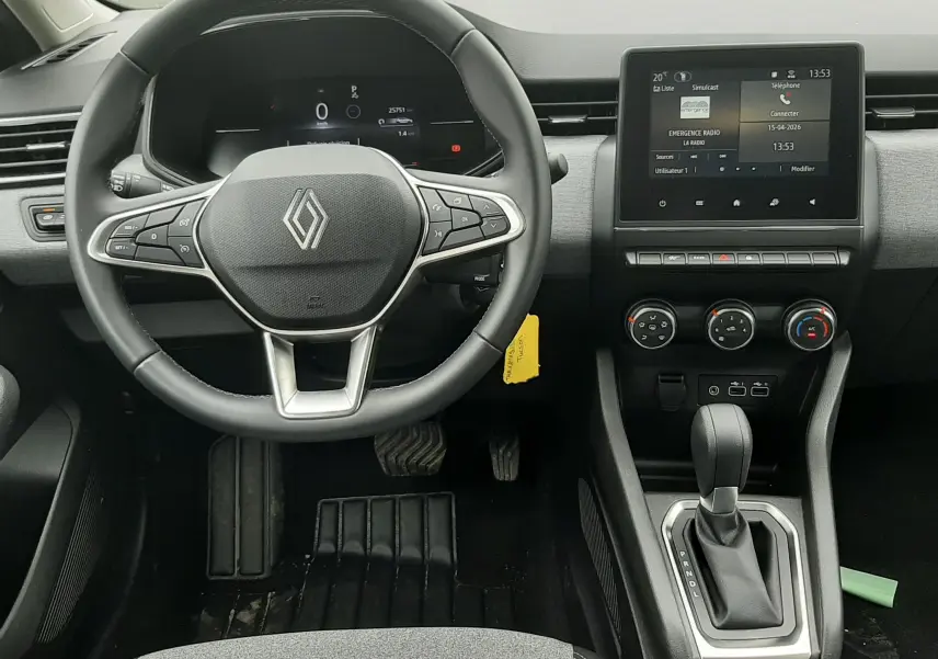 Vue intérieure avant de la Renault Clio V gris schiste, montrant le volant multifonction, l'écran tactile et la console centrale.