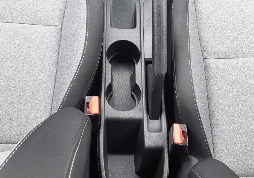 Vue plongeante sur la console centrale noire et les sièges tissu gris clair de la Renault Clio V 2025.