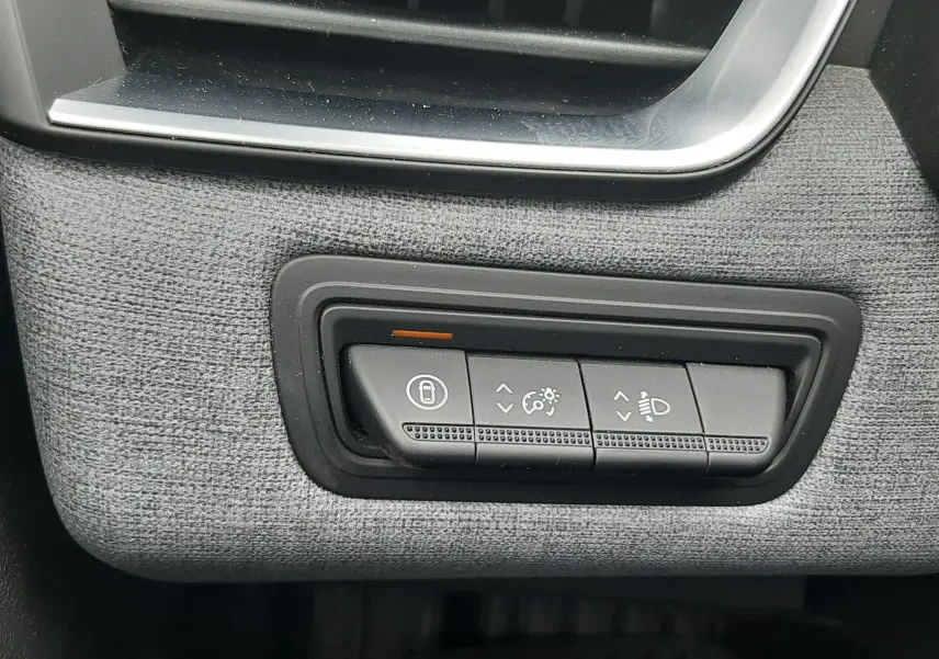 Détail intérieur du tableau de bord gris noir de la Renault Clio V, montrant les commandes d’éclairage et de verrouillage.