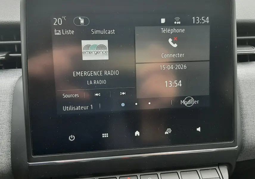 Écran tactile central de la Renault Clio V gris schiste, affichant radio et téléphone, avec commandes climatisation en dessous.