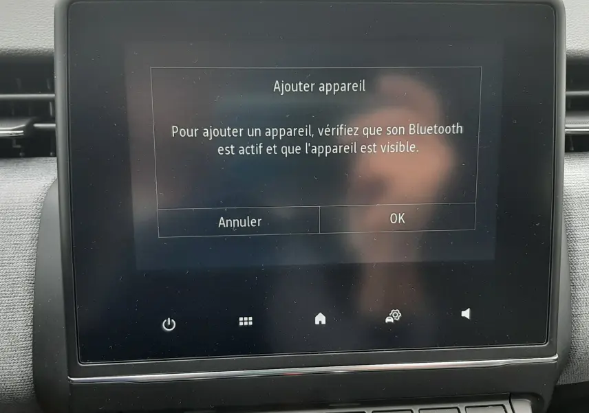 Écran tactile central de la Renault Clio V 2025 affichant l'invite pour ajouter un appareil Bluetooth, avec boutons de commande en dessous.