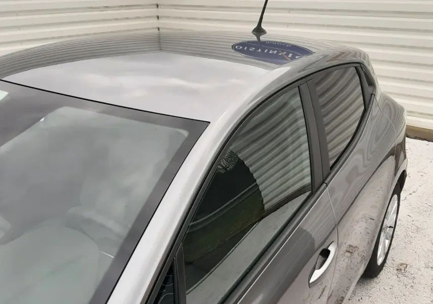 Vue plongeante côté gauche sur la Renault Clio V gris schiste, mettant en valeur ses lignes épurées et vitres teintées.