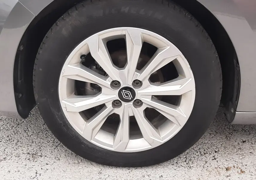 Gros plan sur la roue avant droite de la Renault Clio V gris schiste, avec jante alliage à design géométrique.